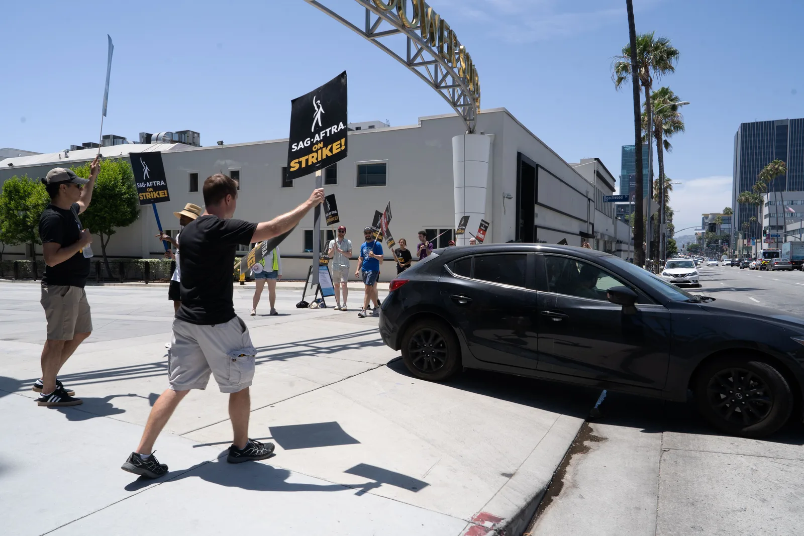 Participants in SAG-AFTRA strike wave signs and protest in a city setting. Which action actors data sources hold up to checking