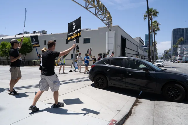 Participants in SAG-AFTRA strike wave signs and protest in a city setting. Which action actors data sources hold up to checking